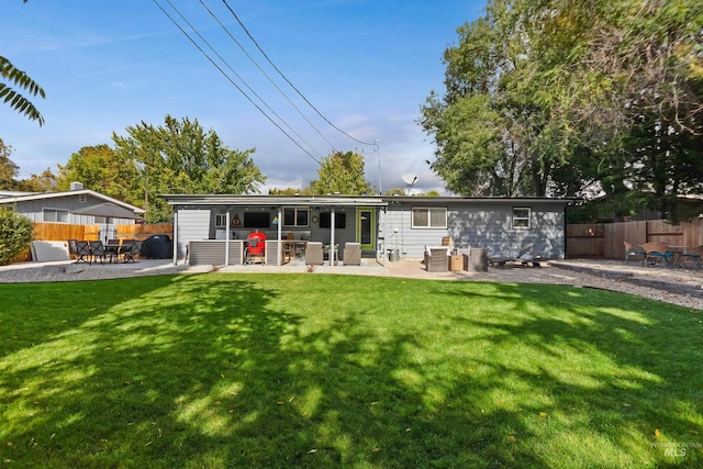 back of house featuring a patio and a lawn