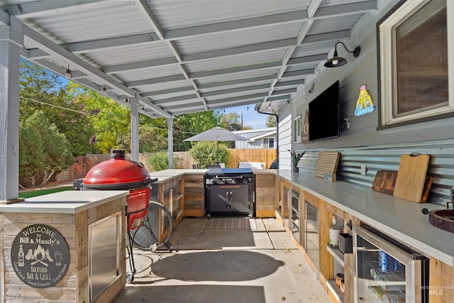 view of patio / terrace featuring an outdoor kitchen, grilling area, and beverage cooler