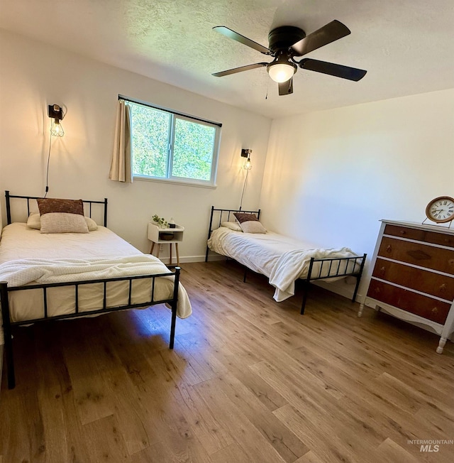 bedroom featuring baseboards, ceiling fan, and wood finished floors