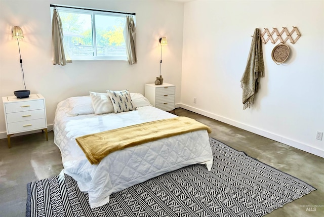 bedroom with baseboards and concrete floors