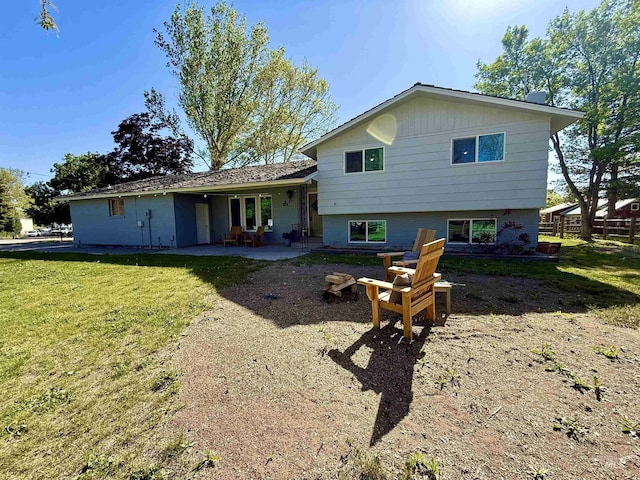 back of property featuring fence, a patio, and a lawn