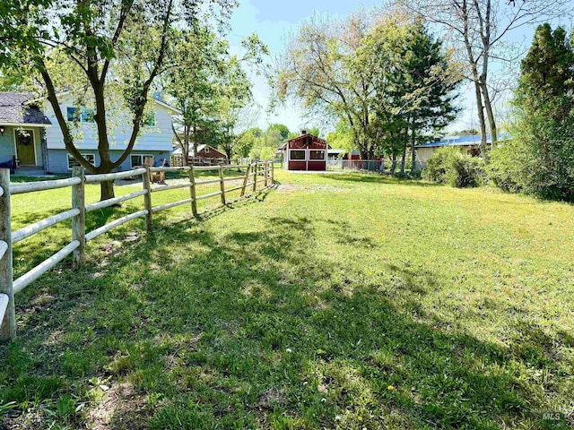 view of yard featuring an outdoor structure, a barn, and fence