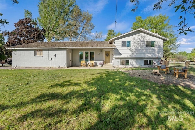 rear view of house featuring a lawn and a patio