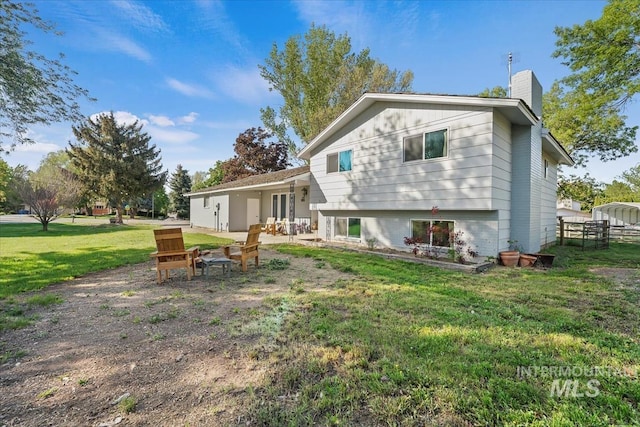 rear view of property featuring a lawn, fence, and a chimney