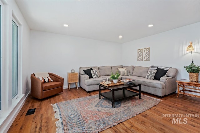 living area with visible vents, recessed lighting, and wood finished floors