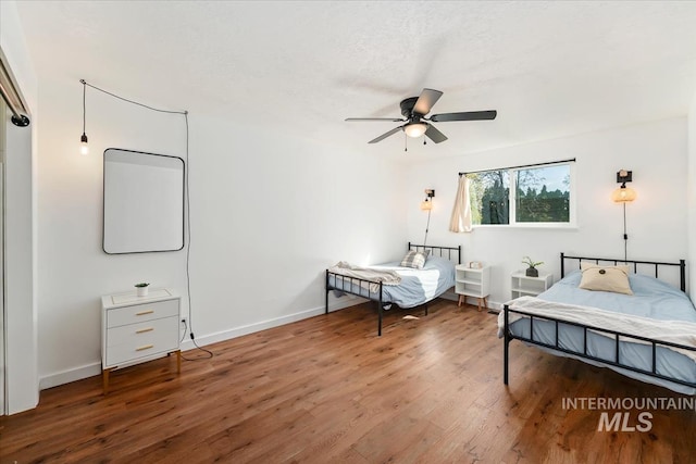 bedroom featuring baseboards, ceiling fan, and wood finished floors