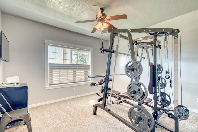 exercise area featuring carpet, ceiling fan, and a textured ceiling