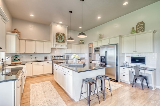 kitchen featuring light hardwood / wood-style floors, a center island, pendant lighting, and stainless steel appliances