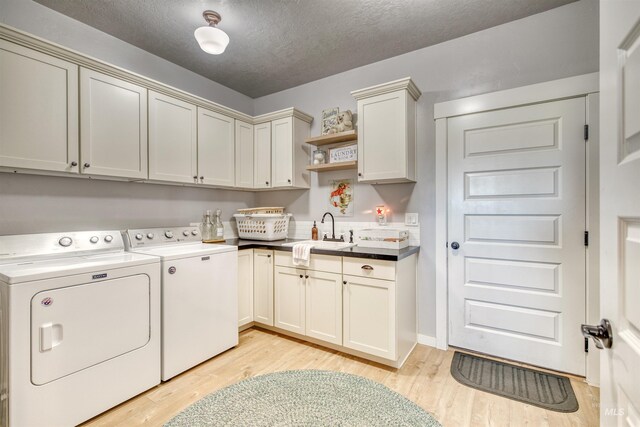 27652 Hop Rd, Caldwell, ID 83607 - washroom with light wood-style floors, a sink, cabinet space, and washer and clothes dryer