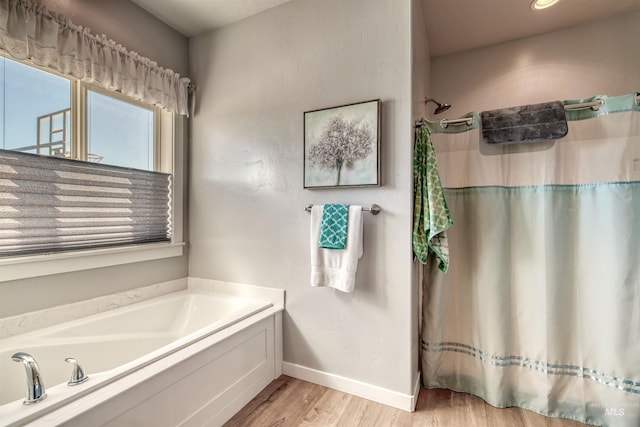 bathroom with independent shower and bath and hardwood / wood-style flooring