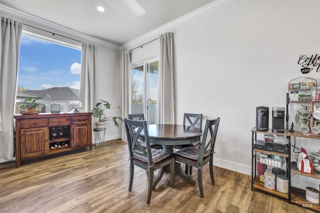 dining area featuring recessed lighting, baseboards, crown molding, and wood finished floors