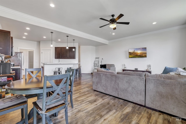 living room featuring recessed lighting, a ceiling fan, ornamental molding, and wood finished floors