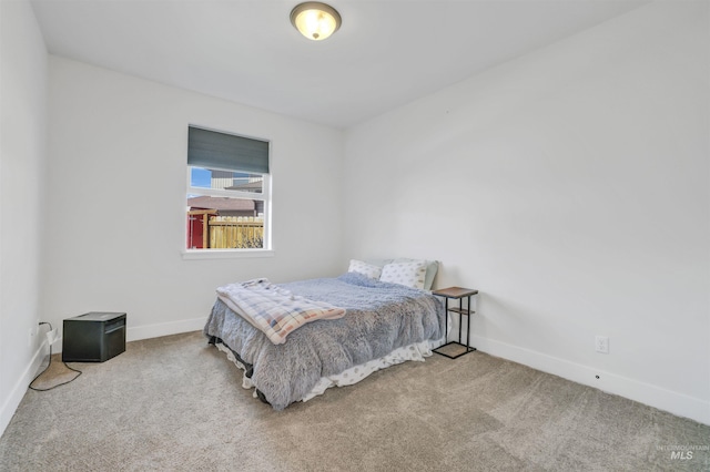 bedroom with baseboards and carpet