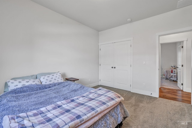 bedroom with a closet, carpet flooring, baseboards, and visible vents