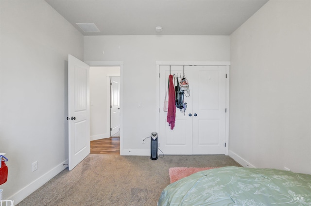 carpeted bedroom featuring a closet and baseboards