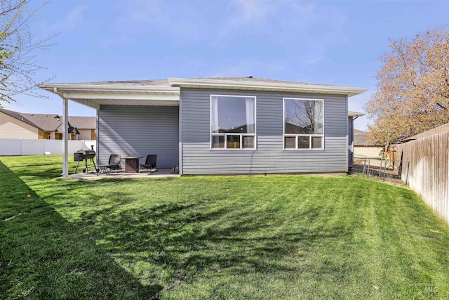 back of property with a patio area, a fenced backyard, and a lawn