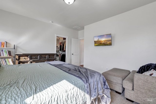 carpeted bedroom with a closet and a walk in closet