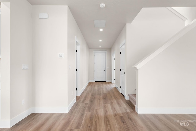 hallway featuring light wood-type flooring and baseboards