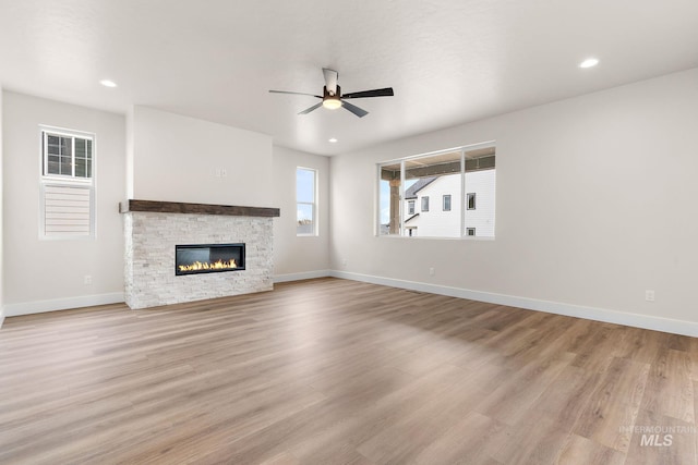 unfurnished living room featuring a fireplace, recessed lighting, ceiling fan, light wood-type flooring, and baseboards