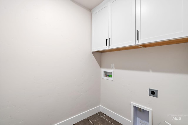 laundry room with cabinet space, baseboards, dark tile patterned flooring, washer hookup, and electric dryer hookup