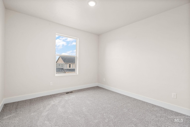 empty room featuring baseboards, visible vents, and carpet flooring