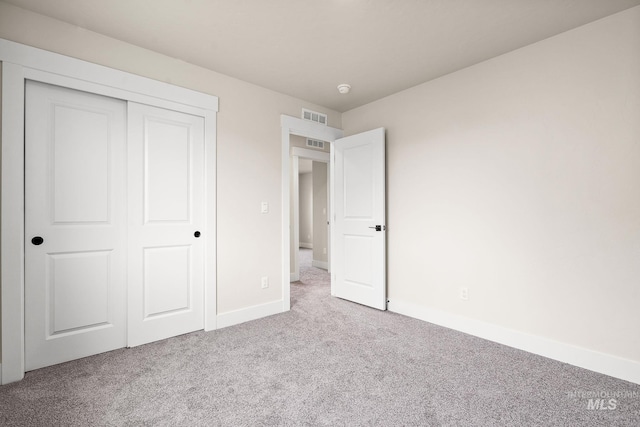 unfurnished bedroom featuring a closet, carpet, visible vents, and baseboards