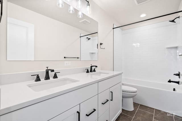 full bath with toilet, double vanity, visible vents, and a sink