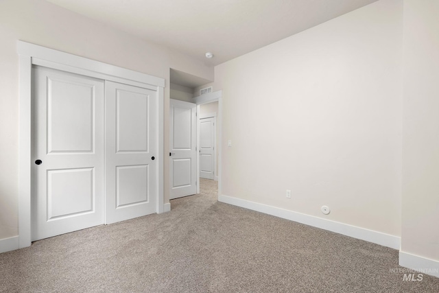 unfurnished bedroom featuring light colored carpet, visible vents, and baseboards