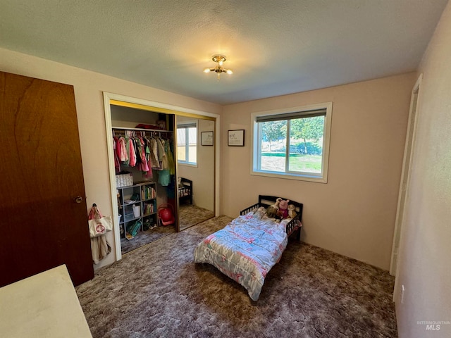 carpeted bedroom featuring a textured ceiling and a closet