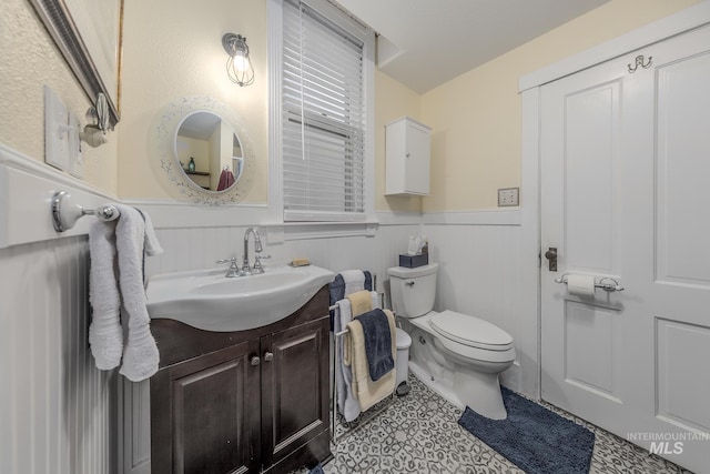 bathroom featuring tile patterned flooring, vanity, and toilet