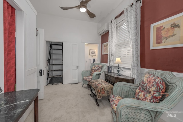 sitting room featuring ceiling fan, light colored carpet, and an AC wall unit