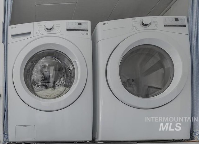 clothes washing area with separate washer and dryer