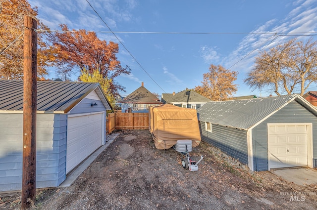 exterior space with a garage and an outbuilding