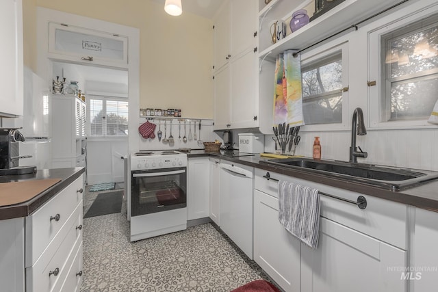 kitchen featuring white appliances, white cabinetry, and sink