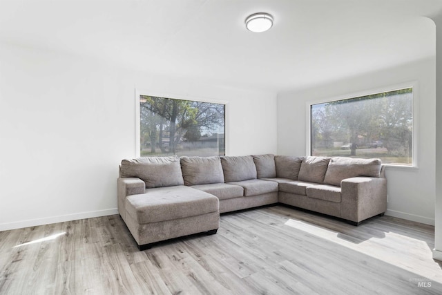 living area featuring light wood-style flooring and baseboards
