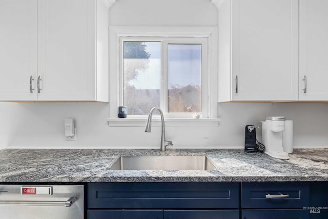 kitchen with a sink, white cabinets, dishwasher, blue cabinetry, and light stone counters