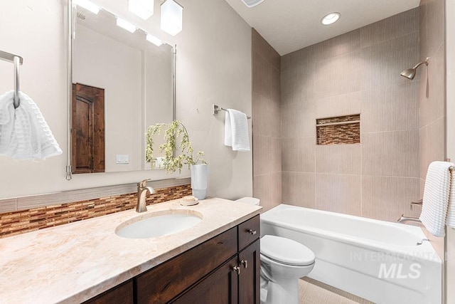 bathroom featuring vanity, tub / shower combination, and toilet