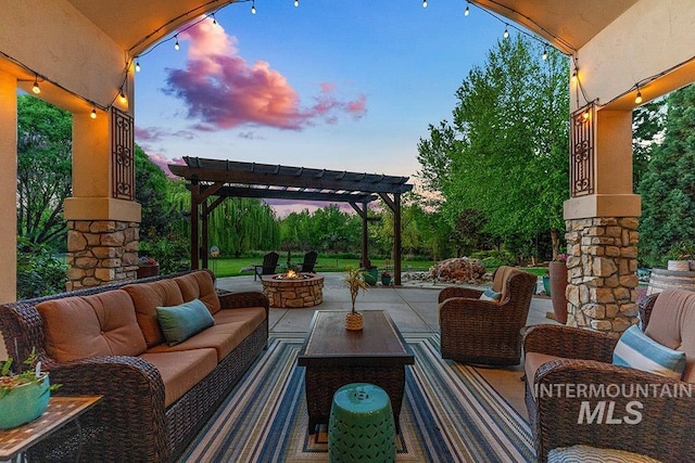 patio terrace at dusk with an outdoor living space with a fire pit and a pergola