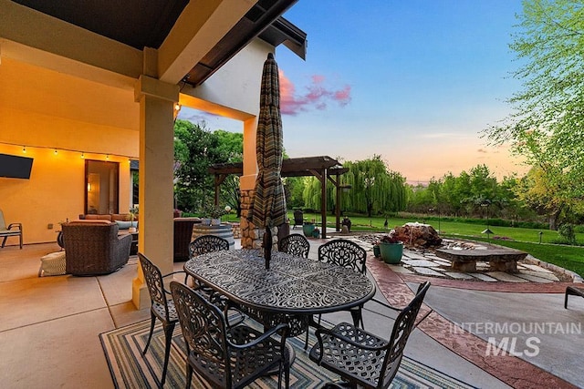 view of patio with outdoor dining area, an outdoor living space with a fire pit, and a pergola