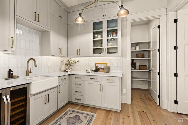 11473 N 17th Way, Boise, ID 83714 - kitchen with beverage cooler, a sink, light countertops, and light wood finished floors
