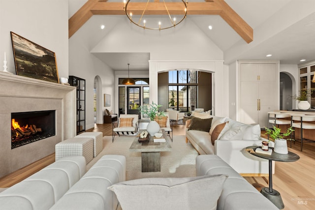 11473 N 17th Way, Boise, ID 83714 - living room with arched walkways, high vaulted ceiling, a chandelier, light wood-style floors, and a premium fireplace