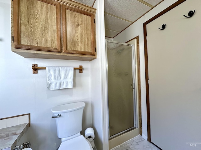 bathroom with a shower with shower door and toilet