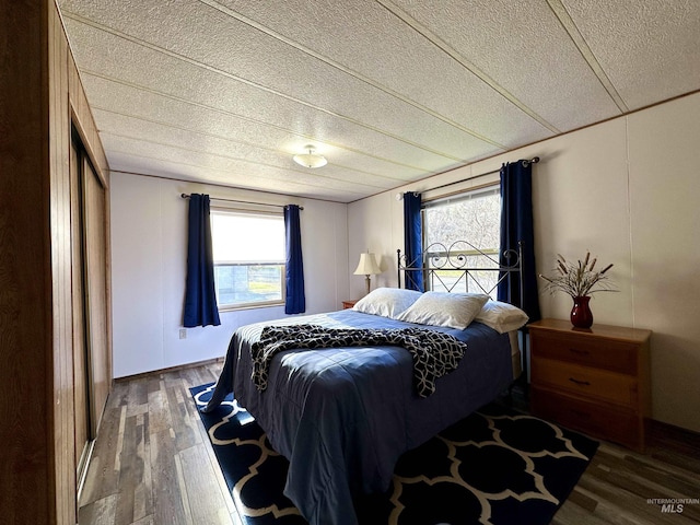 bedroom featuring dark hardwood / wood-style flooring and a textured ceiling