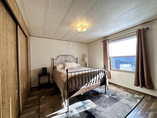 bedroom featuring dark wood-type flooring and a textured ceiling