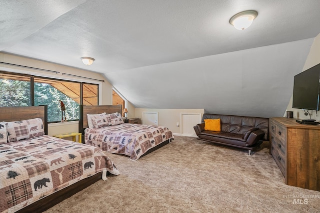 bedroom featuring lofted ceiling, carpet floors, and a textured ceiling