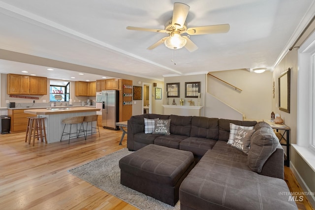 living room with light wood-type flooring and ceiling fan