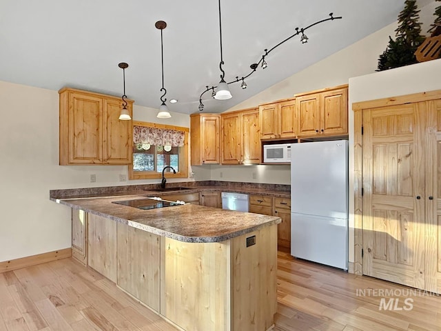 kitchen with a sink, light wood finished floors, white appliances, rail lighting, and vaulted ceiling