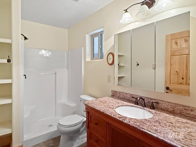 full bathroom with a walk in shower, vanity, and toilet