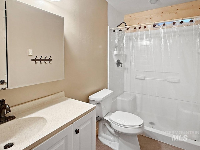 bathroom featuring vanity, toilet, and a shower stall