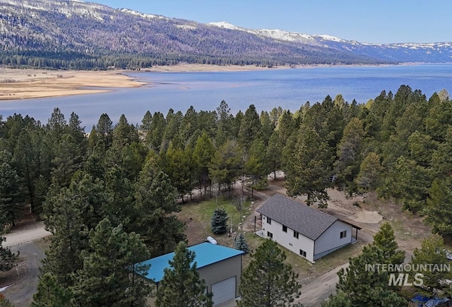 aerial view featuring a wooded view and a water and mountain view